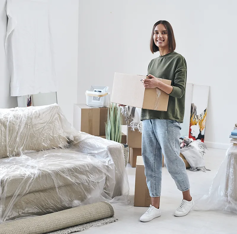CBM Smart Services professional cleaners smiling in a bright, prepared empty room with boxes, ready to perform a stress-free move-in or move-out cleaning service in Massachusetts.