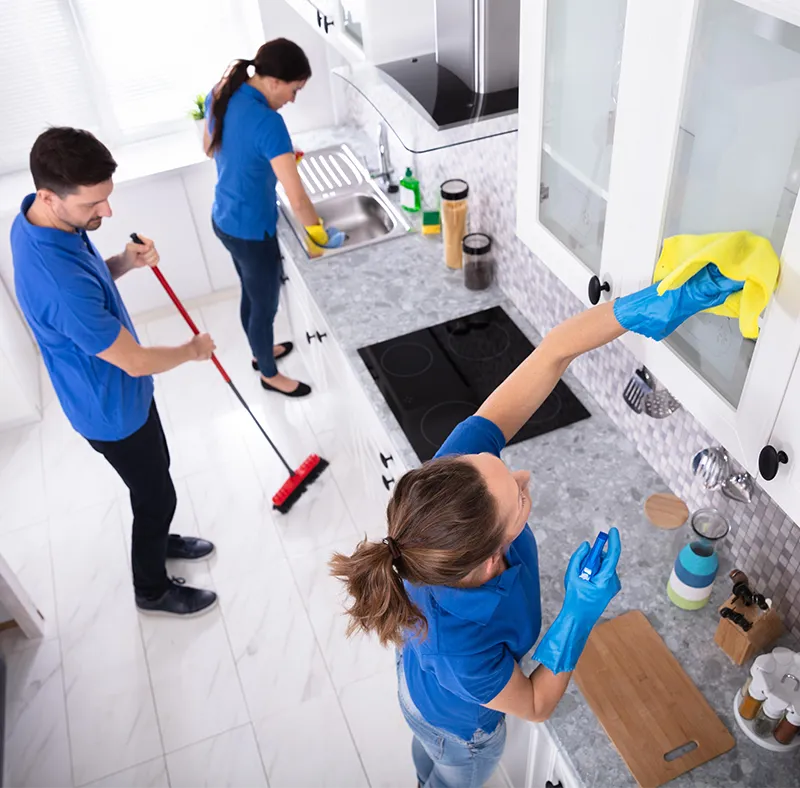 Close-up of a CBM Smart Services professional scrubbing a kitchen countertop with a sponge, demonstrating meticulous residential cleaning detail in Massachusetts.